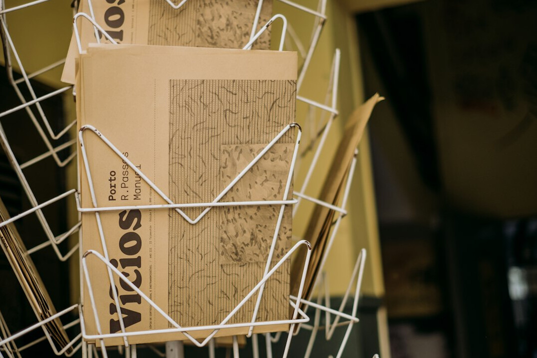 Stack of folded newspapers and printed reports on a table